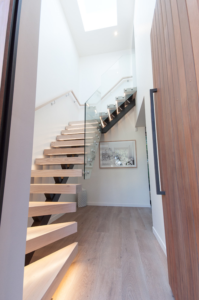 Mittelgroße Moderne Haustür mit weißer Wandfarbe, hellem Holzboden und hellbrauner Holzhaustür in Auckland
