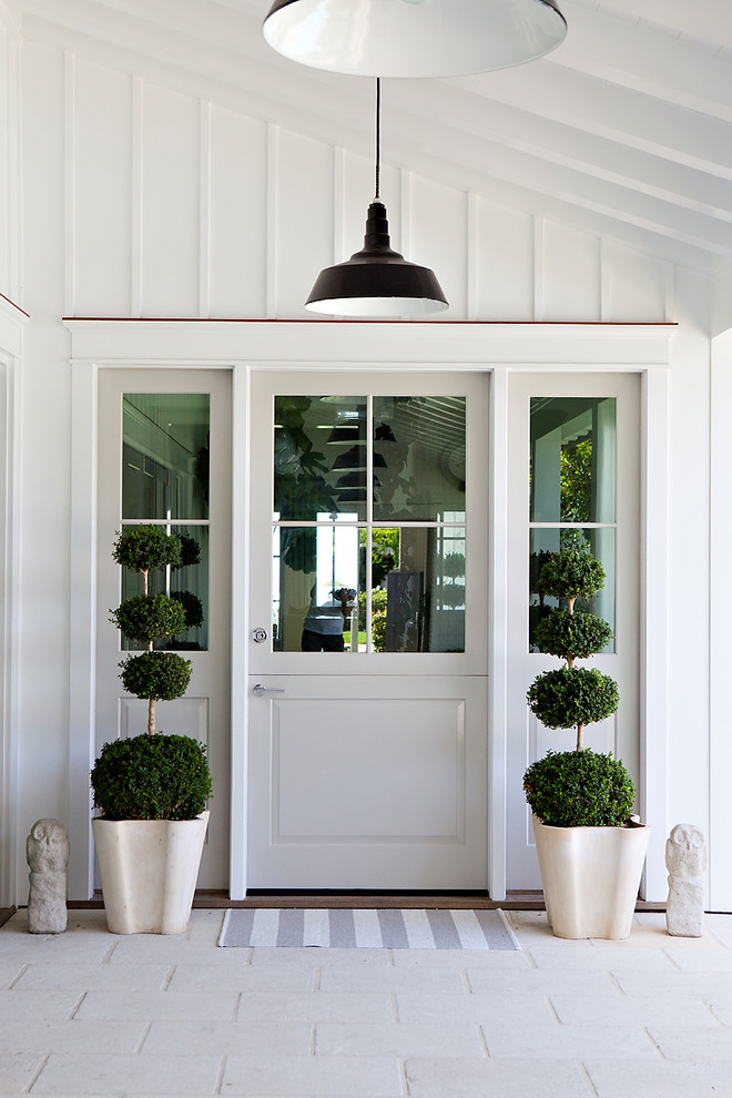 Entryway - coastal entryway idea in Orange County with a glass front door