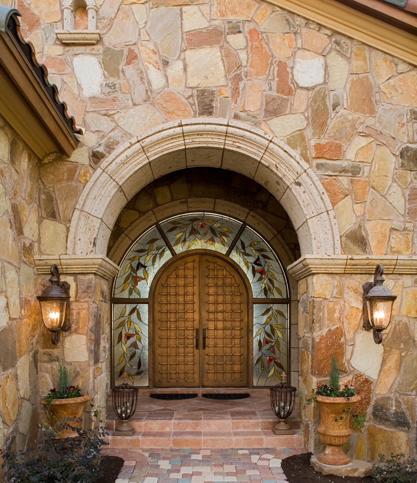 Diseño de entrada mediterránea con puerta doble y puerta de madera en tonos medios