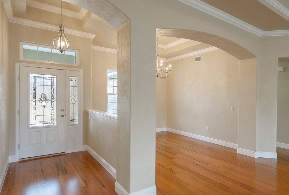 This is an example of a medium sized classic foyer in Miami with beige walls, light hardwood flooring, a single front door and a white front door.