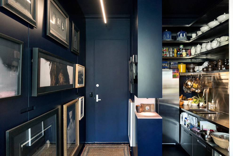 Idee per un corridoio design con pareti blu, pavimento in linoleum, una porta singola, una porta blu e pavimento nero