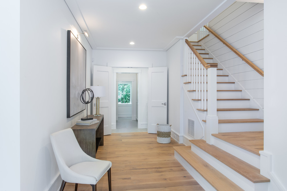 This is an example of a farmhouse foyer in New York with white walls, light hardwood flooring, a single front door, a grey front door and beige floors.