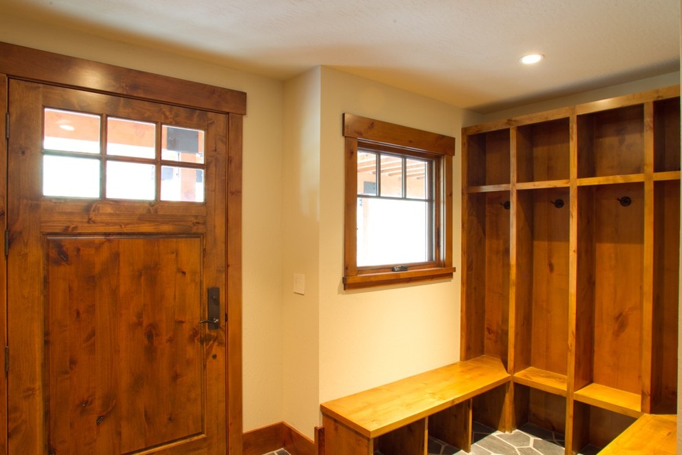 На фото: тамбур в стиле шебби-шик с белыми стенами, полом из сланца и коричневой входной дверью с