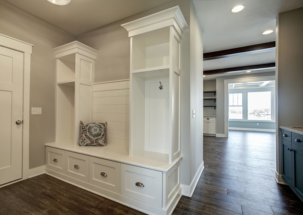 Kleiner Uriger Eingang mit Stauraum, beiger Wandfarbe, braunem Holzboden, Einzeltür, weißer Haustür und braunem Boden in Grand Rapids
