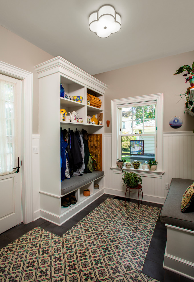 This is an example of a traditional boot room in New York with beige walls and multi-coloured floors.