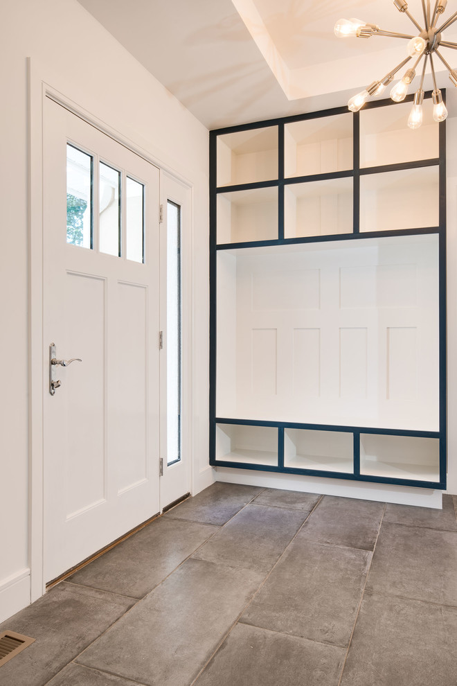 Ispirazione per un ingresso con anticamera design di medie dimensioni con pareti bianche, pavimento in cemento, una porta singola, una porta bianca e pavimento grigio