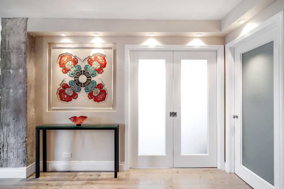 Photo of a medium sized classic foyer in New York with light hardwood flooring, a double front door, grey walls and a glass front door.