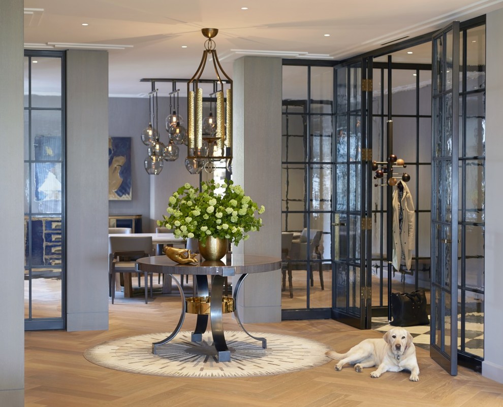 Photo of a traditional foyer in New York with light hardwood flooring and grey walls.