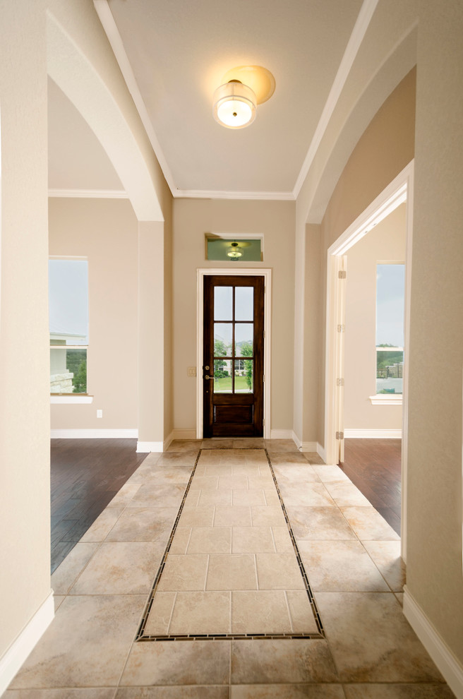 Ispirazione per una porta d'ingresso classica di medie dimensioni con pareti beige, pavimento con piastrelle in ceramica, una porta singola e una porta in legno scuro