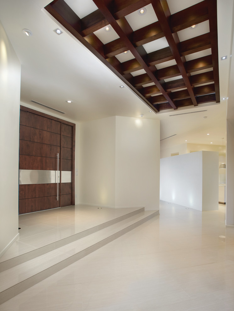 Cette image montre une entrée design avec un mur blanc, une porte simple et une porte en bois foncé.