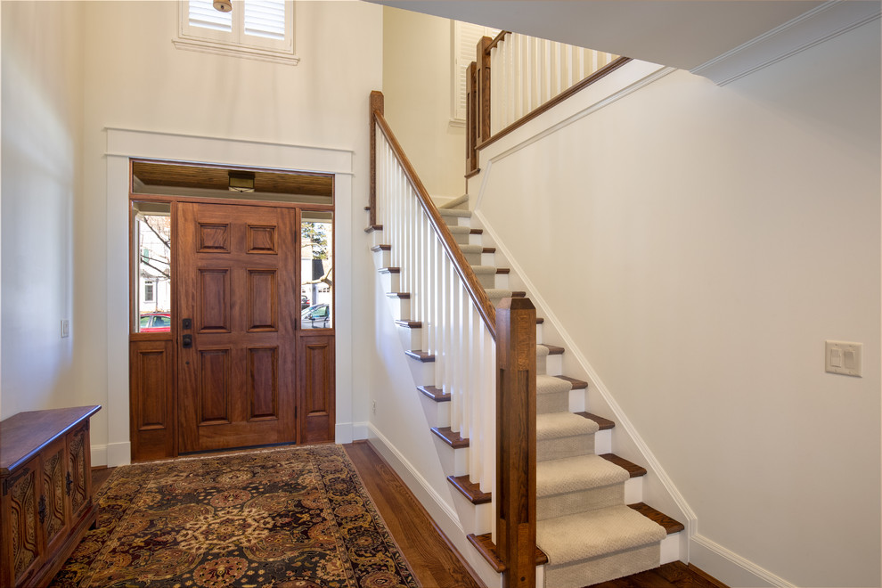 Aménagement d'un hall d'entrée classique avec une porte simple, une porte en bois brun, un mur blanc et un sol en bois brun.