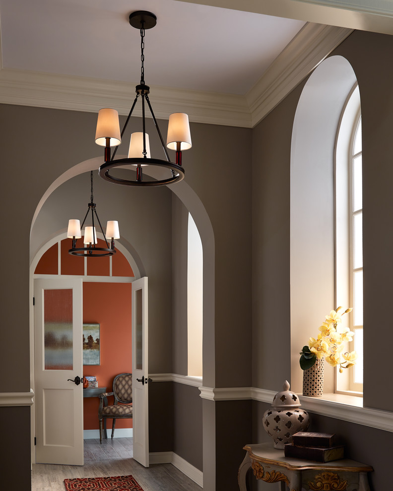 他の地域にある高級な中くらいなトラディショナルスタイルのおしゃれな玄関ロビー (茶色い壁、淡色無垢フローリング、白いドア、茶色い床) の写真