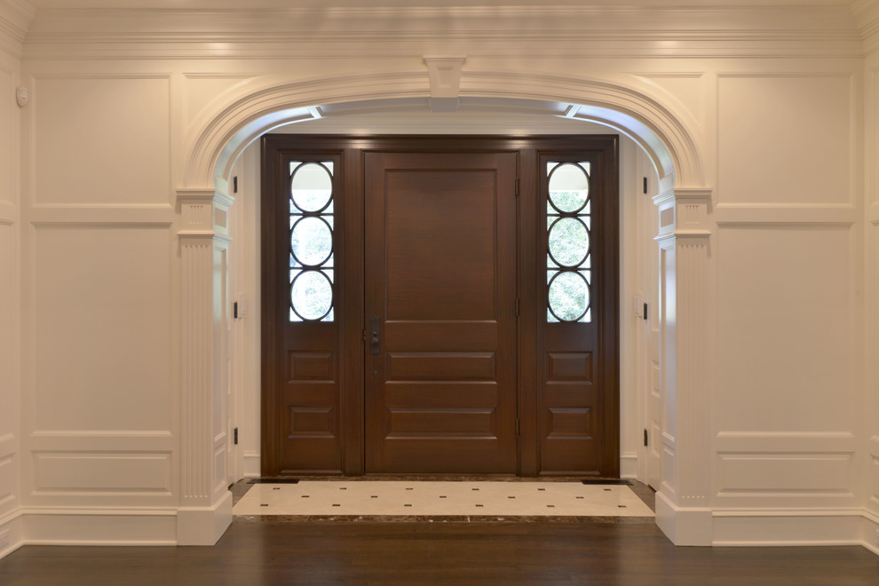 Immagine di un grande ingresso chic con pareti bianche, parquet scuro, una porta singola e una porta in legno scuro