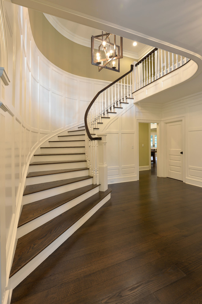 Example of a large classic dark wood floor entryway design in New York with white walls and a dark wood front door