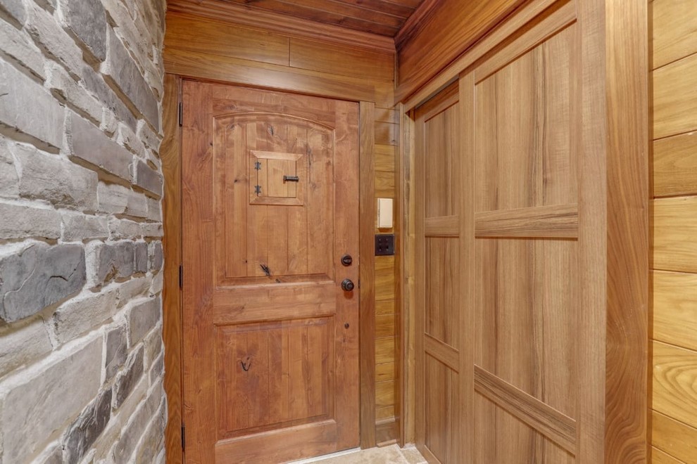 Пример оригинального дизайна: узкая прихожая в стиле рустика с серыми стенами, одностворчатой входной дверью, входной дверью из дерева среднего тона, полом из керамической плитки и бежевым полом