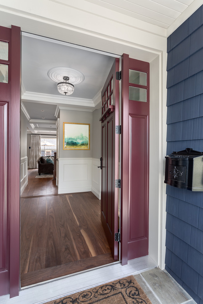 Foto di un corridoio chic con pareti blu, pavimento in legno massello medio, una porta singola e una porta rossa