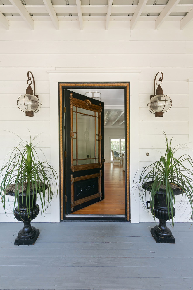 Réalisation d'une porte d'entrée champêtre avec parquet peint, une porte simple et une porte noire.