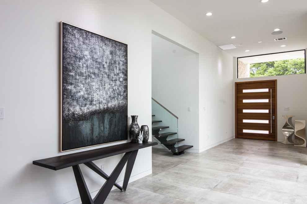 ダラスにある高級な広いコンテンポラリースタイルのおしゃれな玄関ロビー (白い壁、磁器タイルの床、木目調のドア) の写真