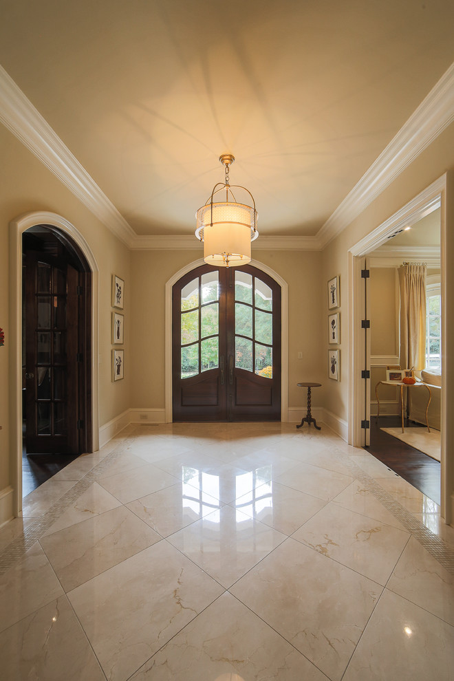 Geräumiges Klassisches Foyer mit beiger Wandfarbe, Marmorboden, Doppeltür, dunkler Holzhaustür und beigem Boden in Charlotte