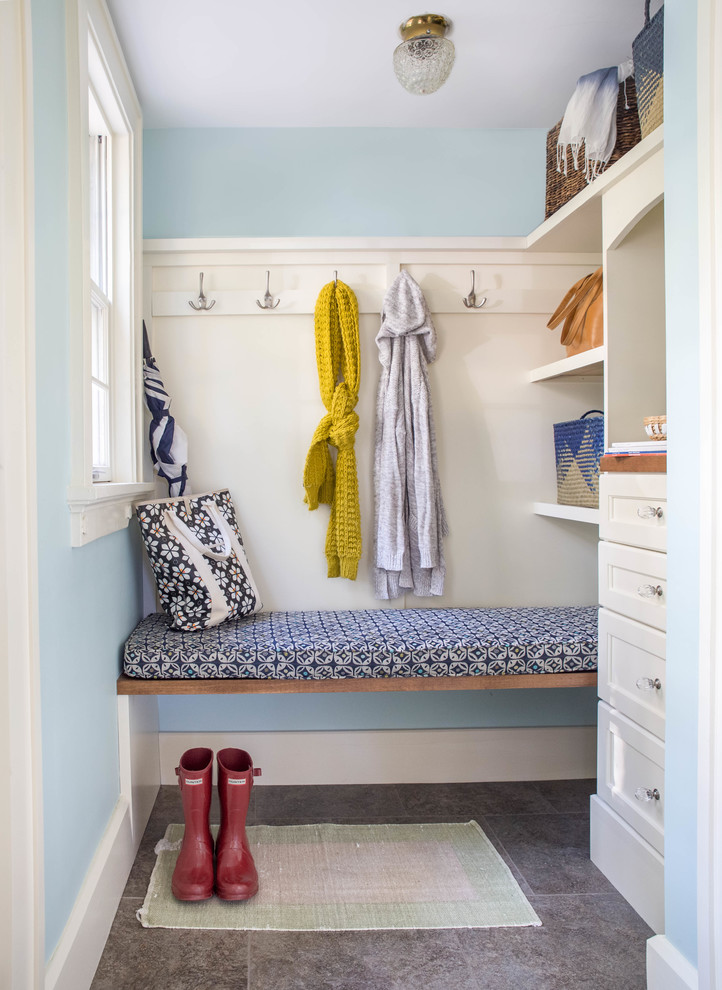 Foto på ett litet funkis kapprum, med blå väggar, klinkergolv i keramik och en vit dörr