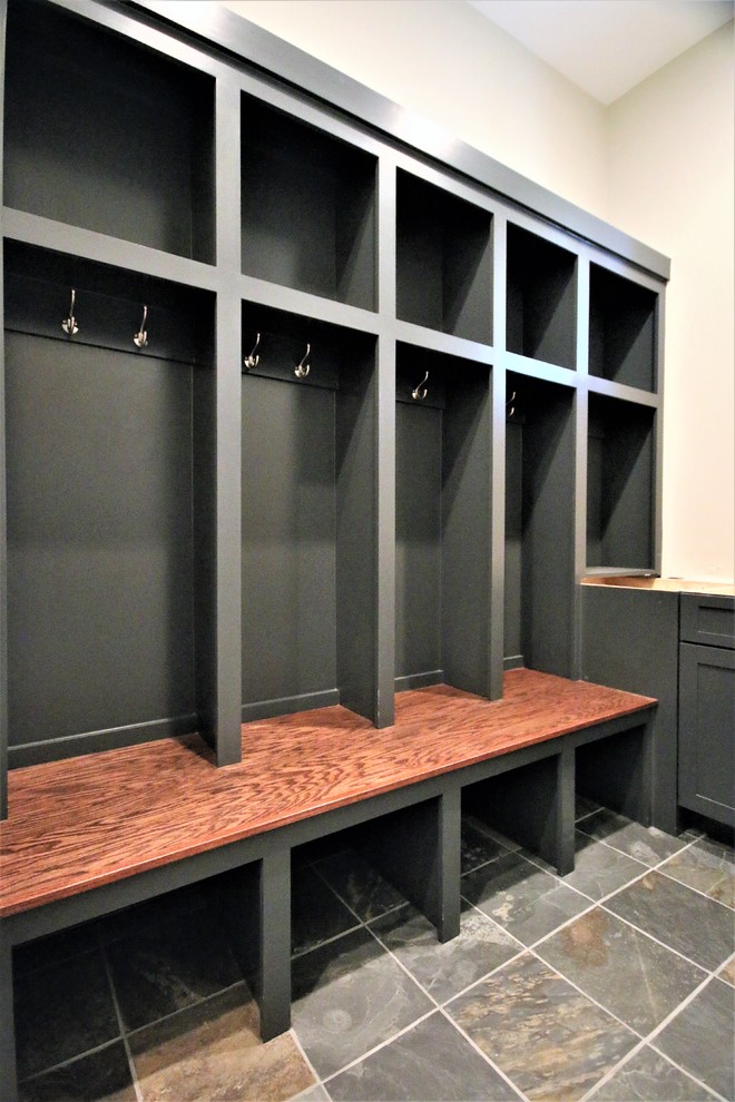 This is an example of a large contemporary boot room in Chicago with beige walls, slate flooring and multi-coloured floors.