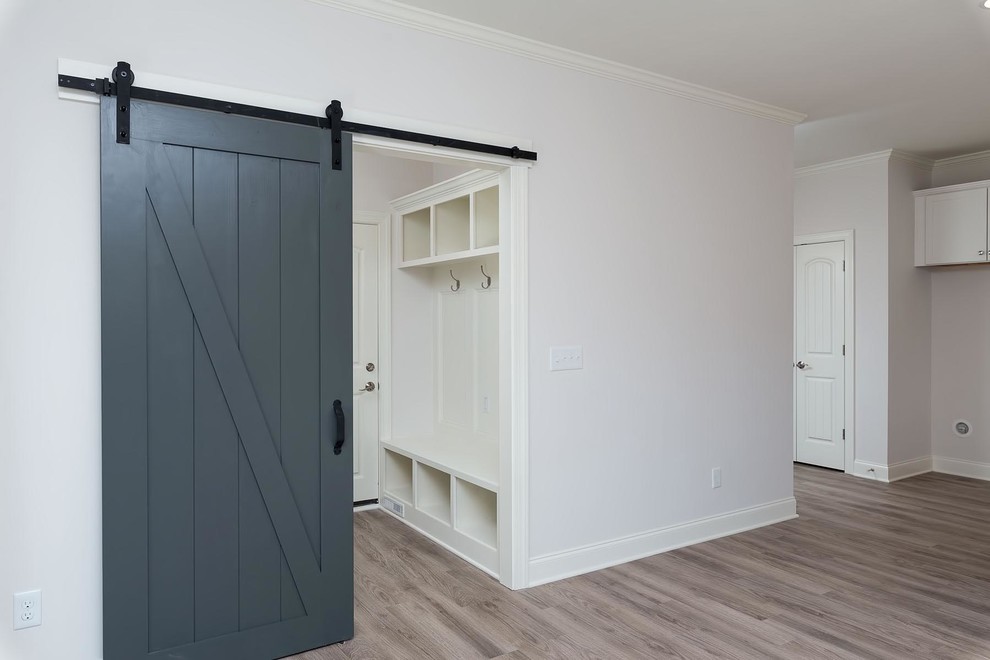 Idée de décoration pour une entrée craftsman de taille moyenne avec un vestiaire, un mur blanc et un sol en vinyl.