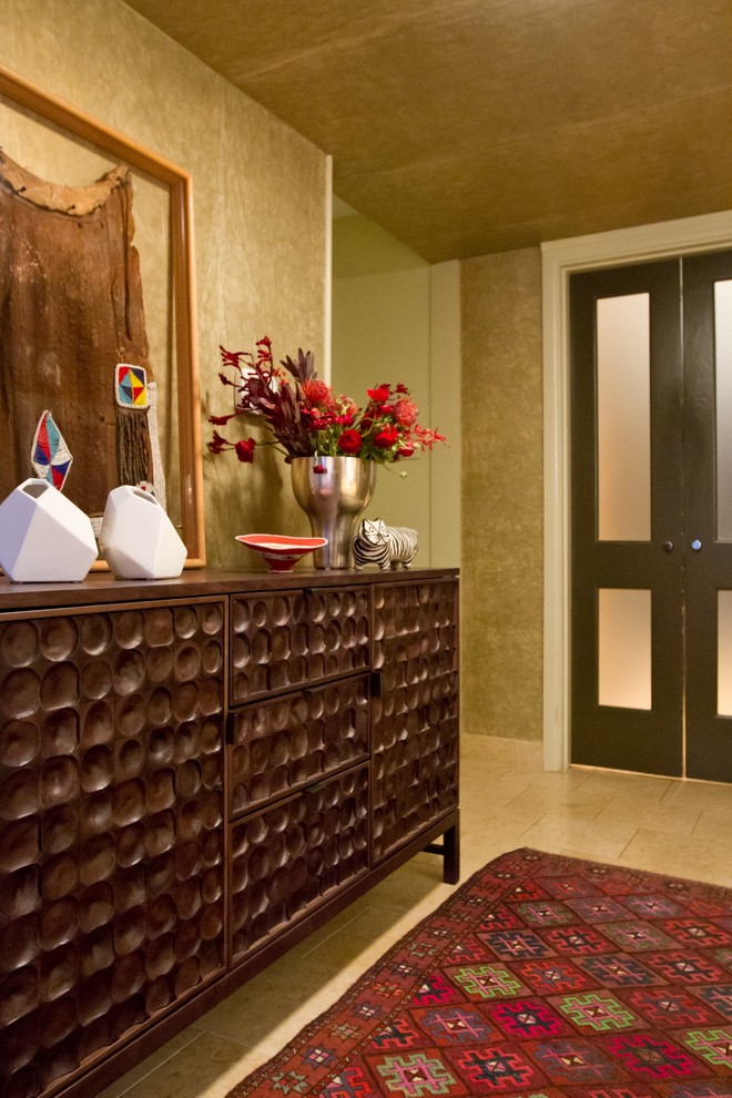 Photo of a small modern foyer in Dallas with metallic walls and limestone flooring.