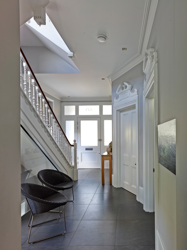 Large contemporary hallway in London with grey walls, ceramic flooring, a single front door and a white front door.