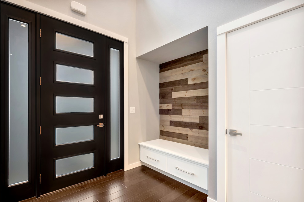 Стильный дизайн: входная дверь в стиле модернизм с серыми стенами, темным паркетным полом, одностворчатой входной дверью, черной входной дверью и коричневым полом - последний тренд