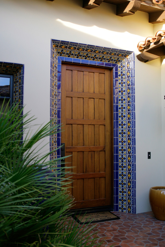 Esempio di una porta d'ingresso mediterranea di medie dimensioni con una porta singola e una porta in legno bruno