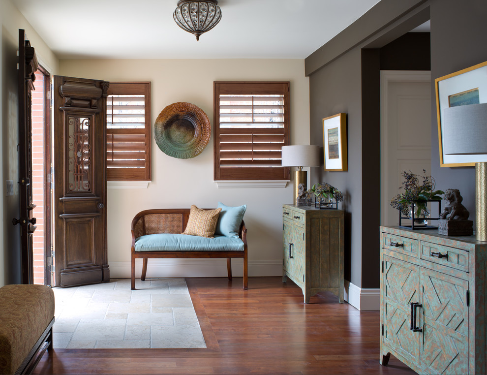 デンバーにあるラグジュアリーな中くらいなトランジショナルスタイルのおしゃれな玄関ラウンジ (マルチカラーの壁、濃色無垢フローリング、濃色木目調のドア、茶色い床) の写真