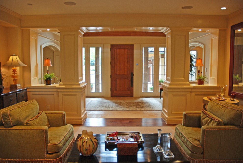 На фото: фойе среднего размера в классическом стиле с белыми стенами, полом из керамической плитки, одностворчатой входной дверью, входной дверью из темного дерева и бежевым полом с