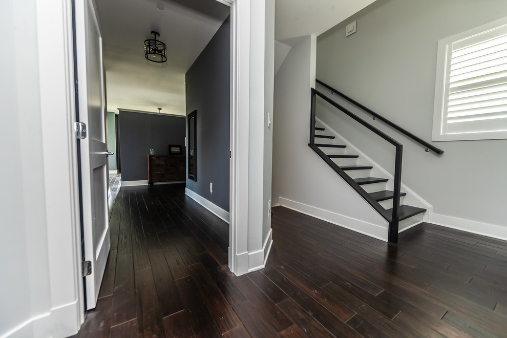 Aménagement d'une entrée craftsman de taille moyenne avec un couloir, parquet foncé, un sol marron et un mur gris.