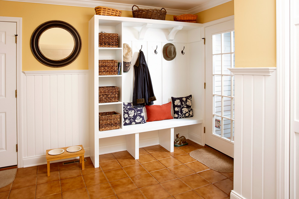 Photo of a medium sized classic boot room in New York with yellow walls, ceramic flooring, a single front door and a glass front door.