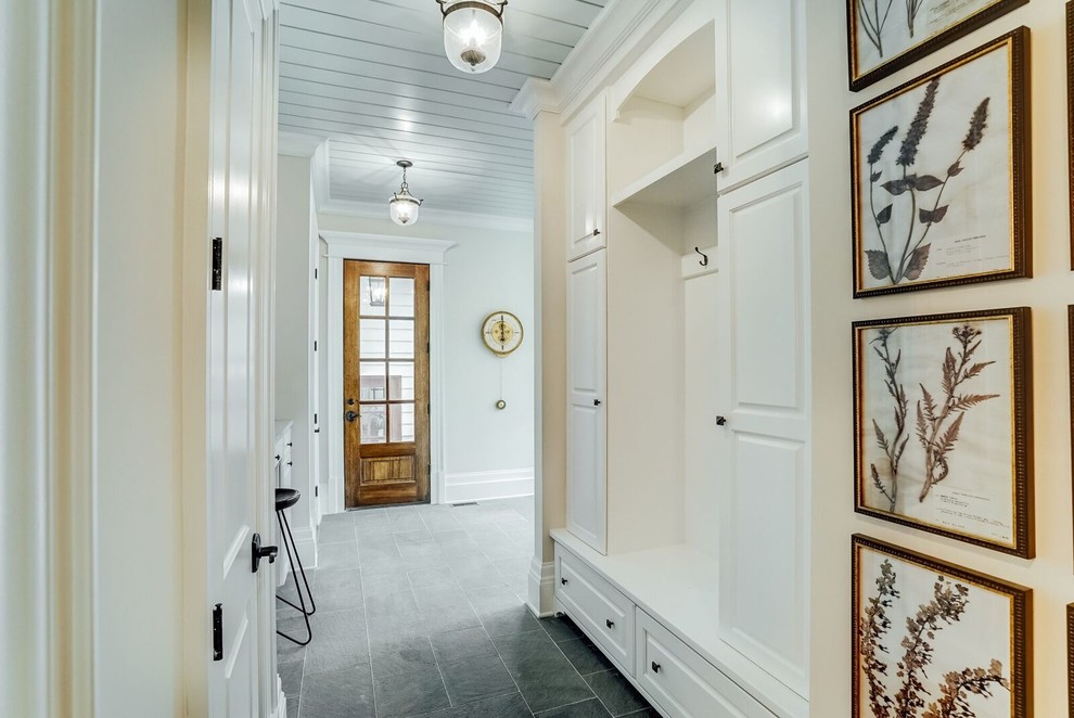 Idée de décoration pour une grande entrée tradition avec un vestiaire, un mur beige, une porte simple et une porte en bois brun.