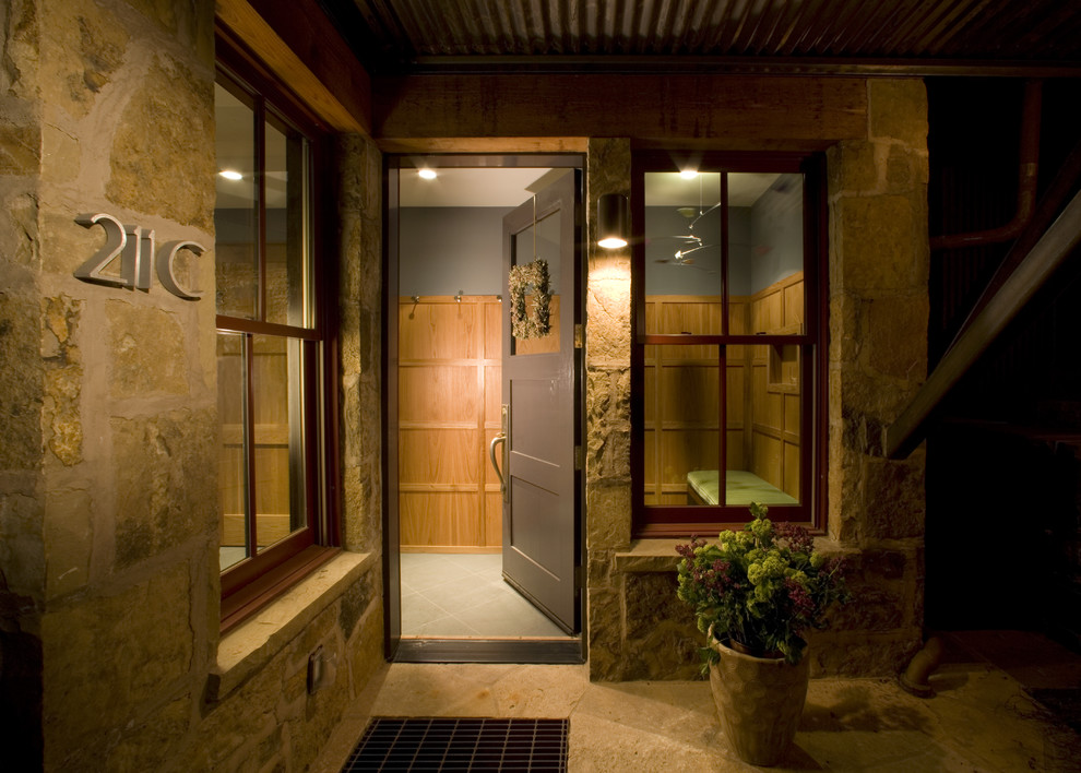 This is an example of a contemporary entrance in DC Metro with a single front door and a dark wood front door.
