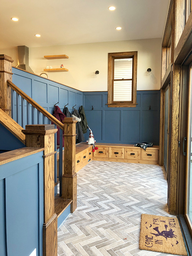 Cette photo montre une entrée craftsman de taille moyenne avec un vestiaire, un mur bleu, un sol en carrelage de céramique, une porte simple et un sol gris.