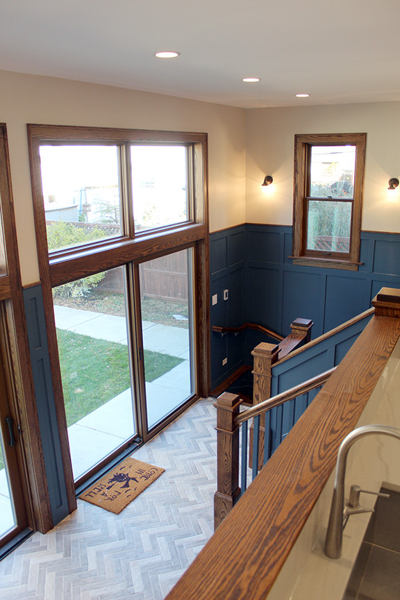 Cette image montre une entrée craftsman de taille moyenne avec un vestiaire, un mur bleu, un sol en carrelage de céramique, une porte simple et un sol gris.