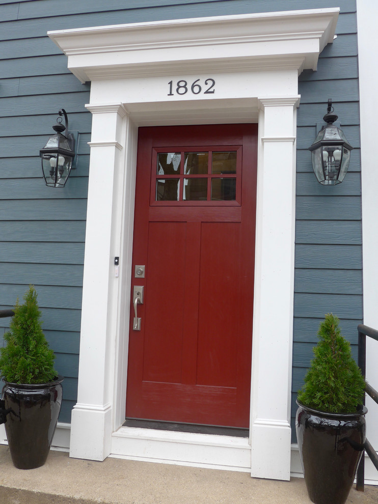 Idées déco pour une porte d'entrée victorienne de taille moyenne avec un mur bleu, sol en béton ciré, une porte simple, une porte rouge et un sol beige.