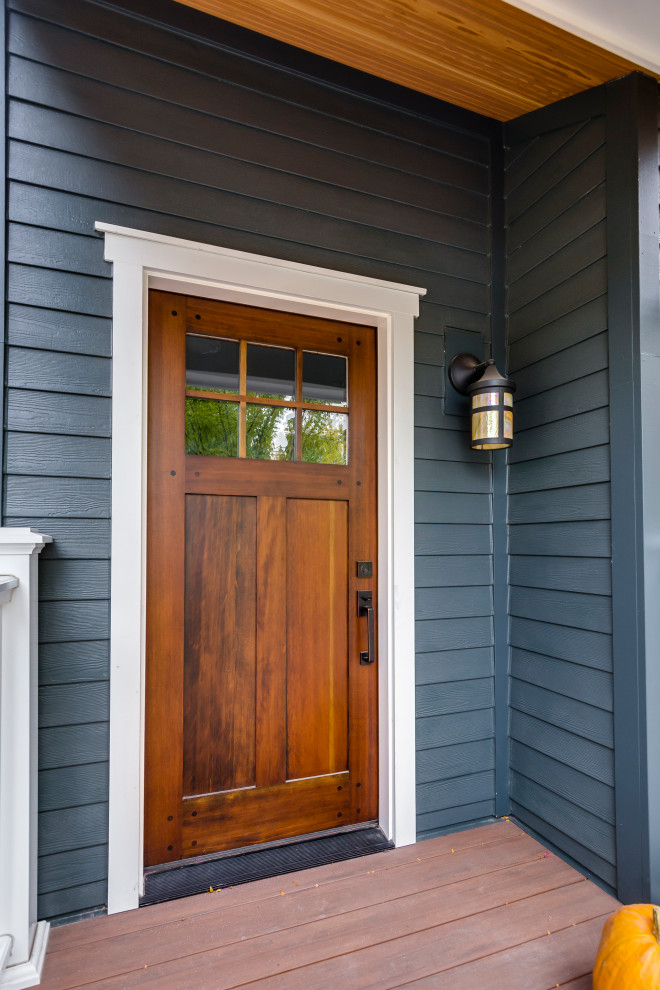 Пример оригинального дизайна: входная дверь среднего размера в викторианском стиле с серыми стенами, деревянным полом, одностворчатой входной дверью, коричневой входной дверью, коричневым полом, деревянным потолком и панелями на части стены