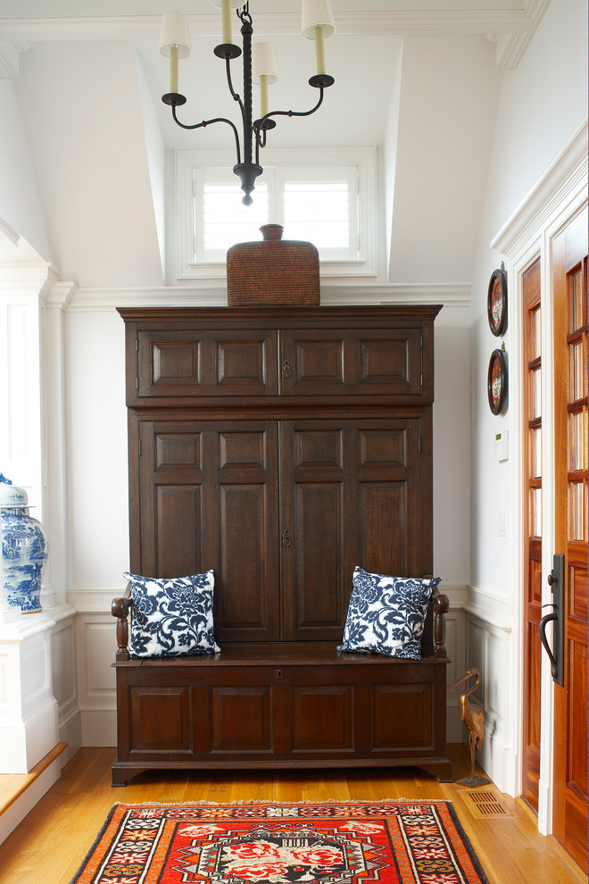 Entryway - traditional medium tone wood floor and brown floor entryway idea in Miami with white walls