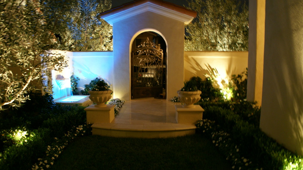 Пример оригинального дизайна: маленькая входная дверь в средиземноморском стиле с бежевыми стенами, полом из травертина, одностворчатой входной дверью, стеклянной входной дверью и бежевым полом для на участке и в саду