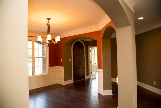 Modelo de puerta principal de estilo americano de tamaño medio con paredes beige, suelo de madera oscura, puerta simple y puerta de madera en tonos medios