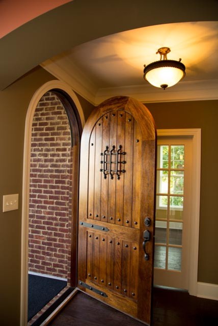 Cette image montre une entrée craftsman de taille moyenne avec un mur beige, parquet foncé, une porte simple et une porte en bois brun.