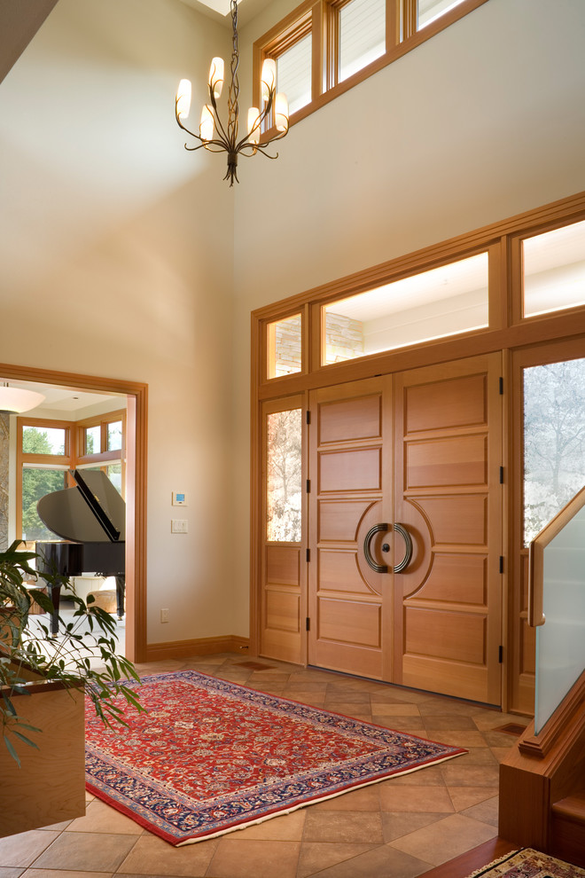 Foto de entrada contemporánea con paredes beige, puerta doble y puerta de madera en tonos medios