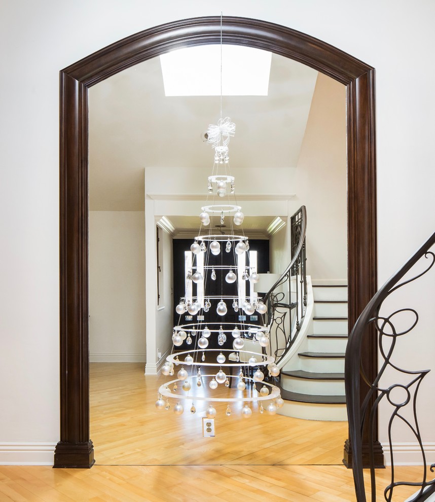 Cette photo montre un hall d'entrée moderne de taille moyenne avec un mur blanc, parquet clair, une porte simple, une porte en bois foncé et un sol jaune.