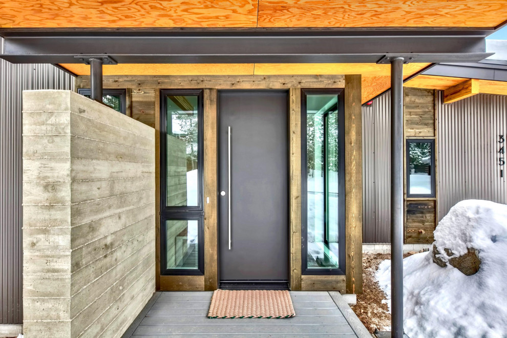 Ejemplo de puerta principal moderna pequeña con paredes metalizadas, suelo de cemento, puerta simple, puerta negra y suelo gris