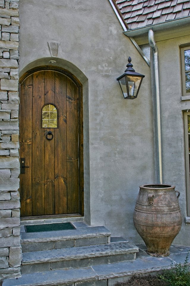 Foto di una grande porta d'ingresso mediterranea con pareti grigie, una porta singola e una porta in legno bruno