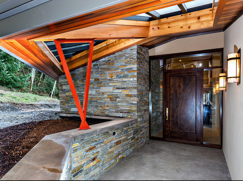 This is an example of a large contemporary front door in Seattle with beige walls, concrete flooring, a single front door and a dark wood front door.