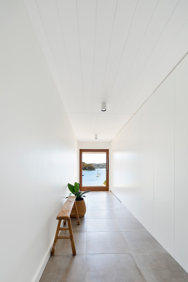 Design ideas for a contemporary hallway in Sydney with white walls, a single front door, a glass front door and grey floors.